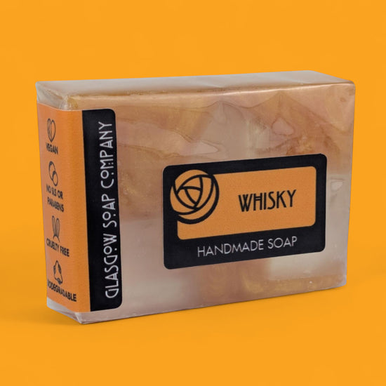 Handmade soap bar Whisky packaging on an orange background
