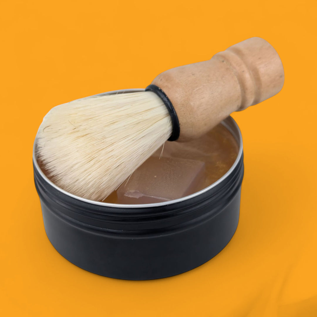 Shaving brush and black container on an orange background