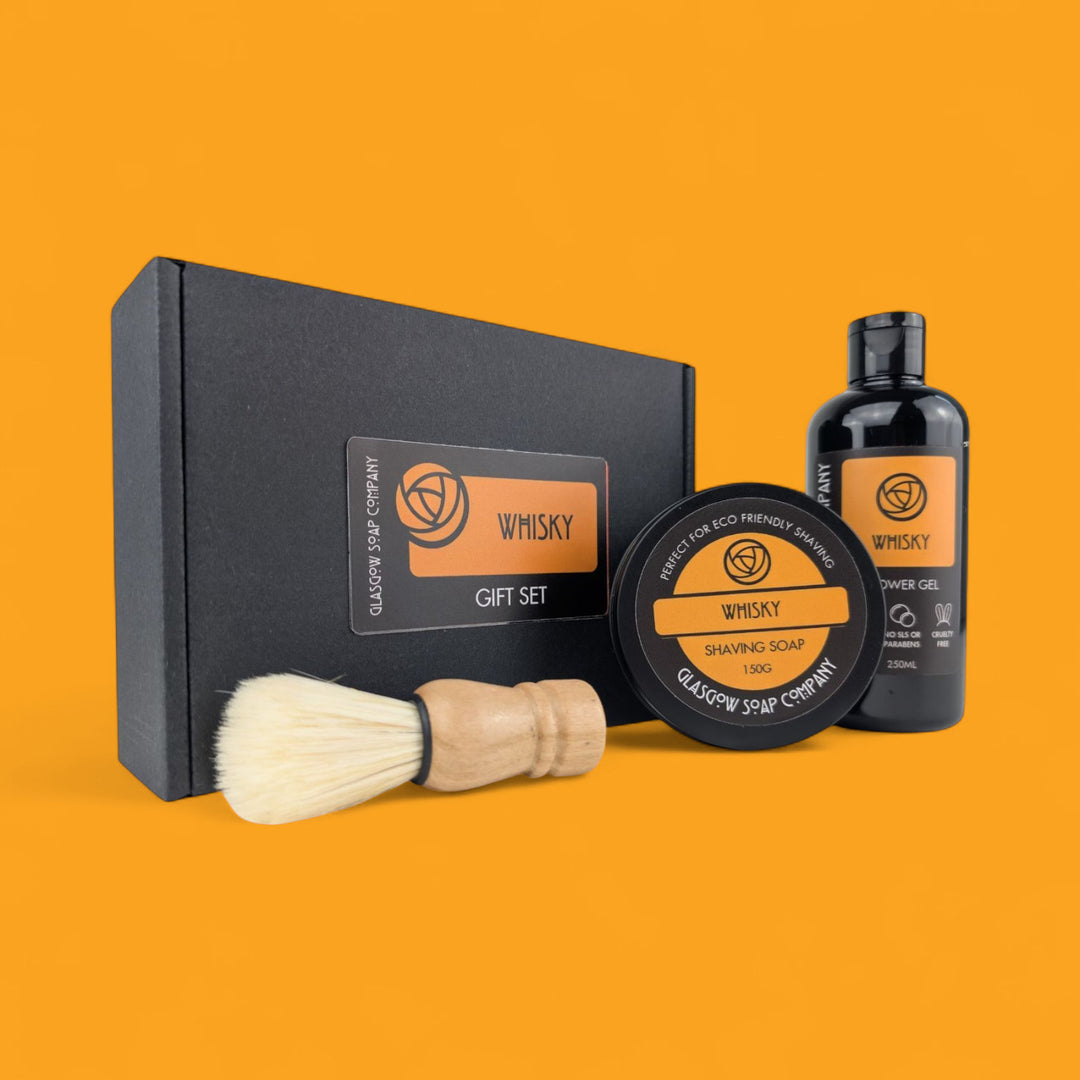 Gift set with shaving brush, soap, and gel on an orange background
