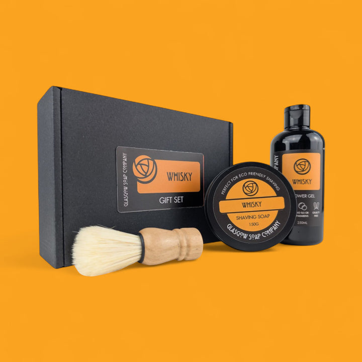 Gift set with shaving brush, soap, and gel on an orange background