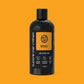 Black bottle of Glasgow Soap Company Whisky Shower Gel on an orange background