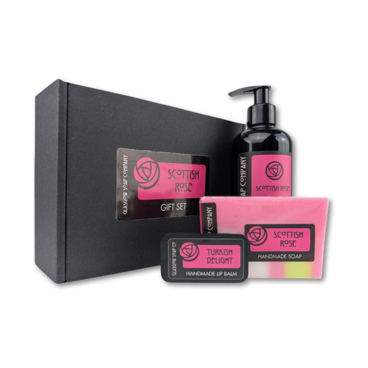 Scottish Rose gift set with black box, handmade soap, liquid soap, and lip balm on a white background
