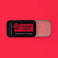 Handmade lip balm labeled 'Strawberry Daiquiri' on a red background