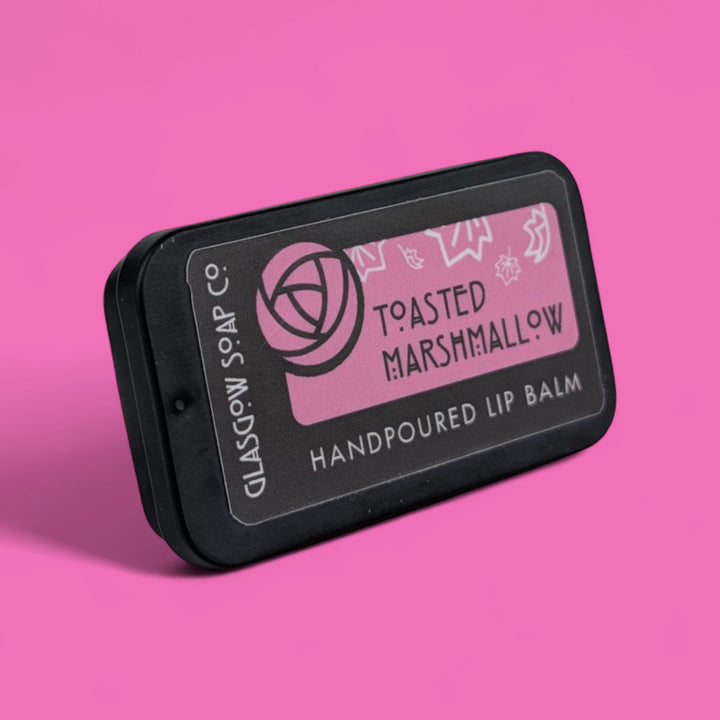 Handpoured lip balm packaging with 'Toasted Marshmallow' flavor on a pink background